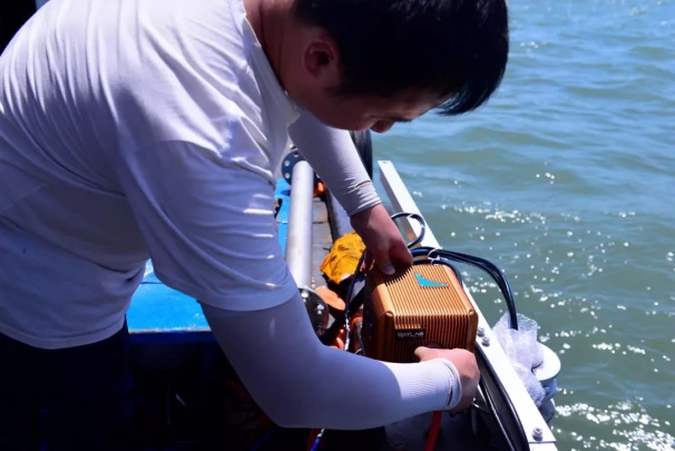 Technician connecting navigation equipment aboard the Bangkok survey vessel