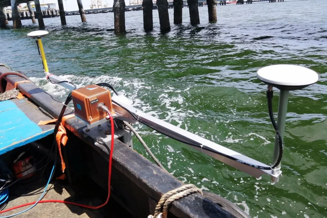 Survey vessel with navigation equipment and two GNSS antennas beside quay piles in Bangkok